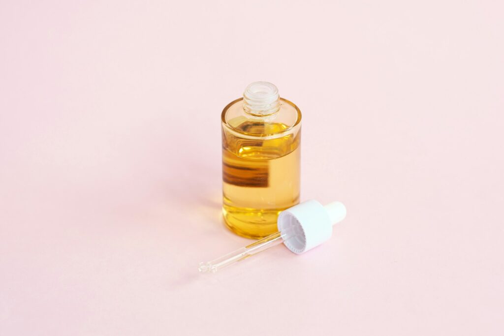 Dropper applying treatment serum directly to scalp for hair growth stimulation
