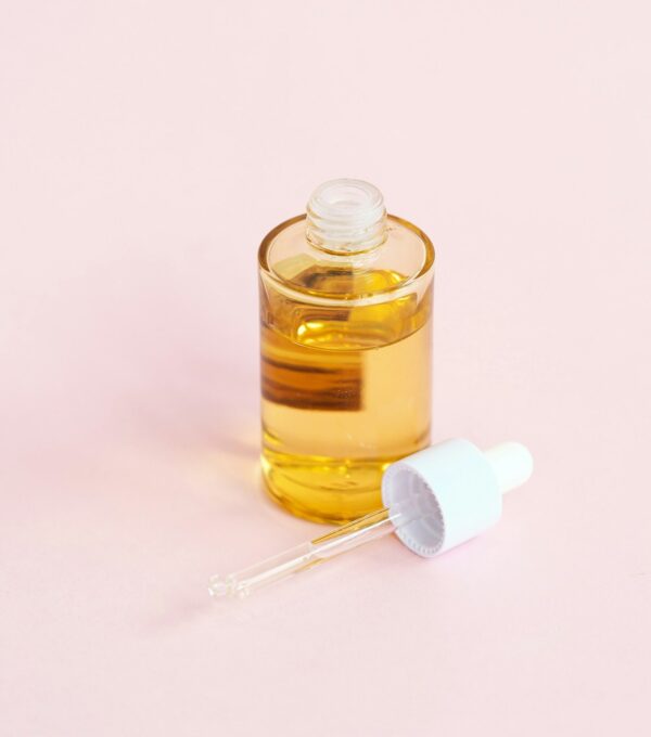 Dropper applying treatment serum directly to scalp for hair growth stimulation