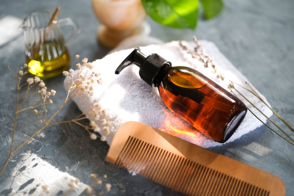Amber pump bottle and wooden comb for a gentle hair and scalp aftercare routine